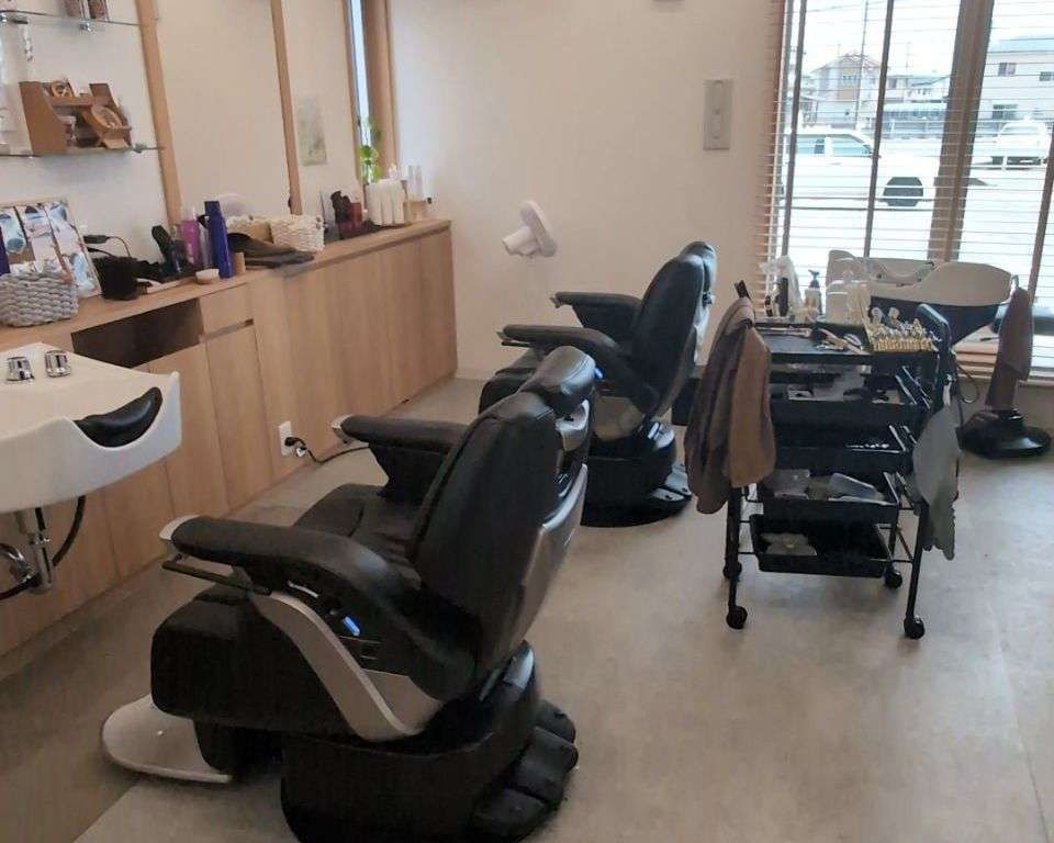 窓から光が入る店内。理容椅子とシャンプー台